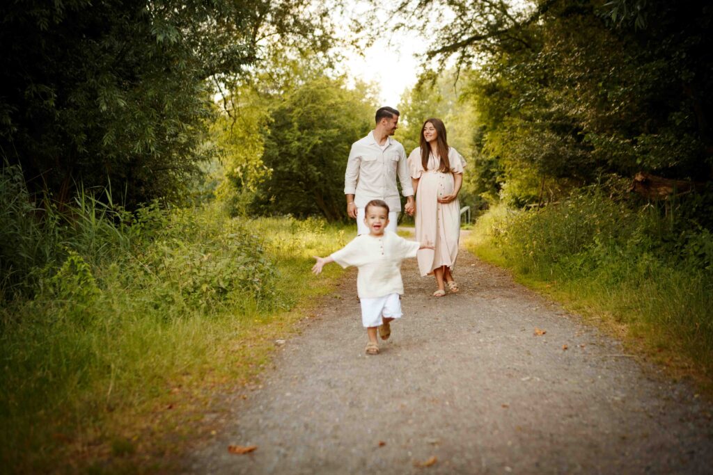 Familie beim Spaziergang: Kind läuft fröhlich vor den Eltern