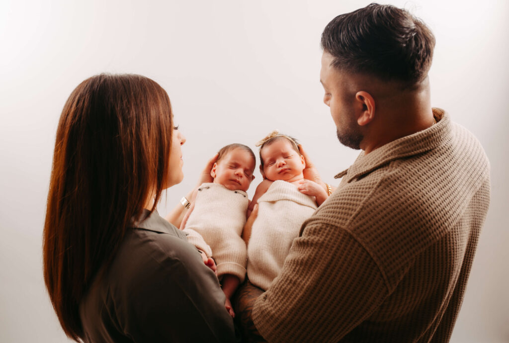 Eltern halten liebevoll ihre Zwillingsbabys im Arm