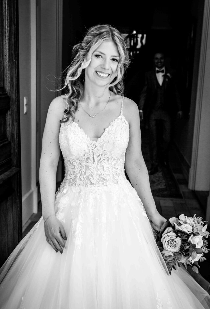 Braut im Fokus, Bräutigam steht im Hintergrund