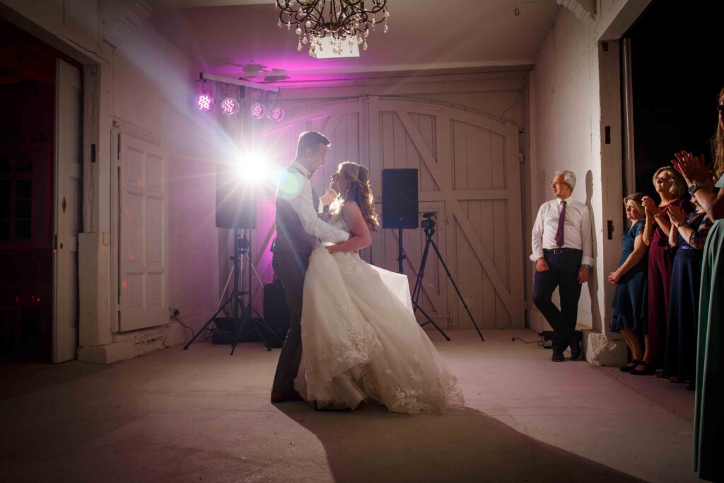 Hochzeitstanz auf der Tanzfläche mit applaudierenden Gästen im Hintergrund