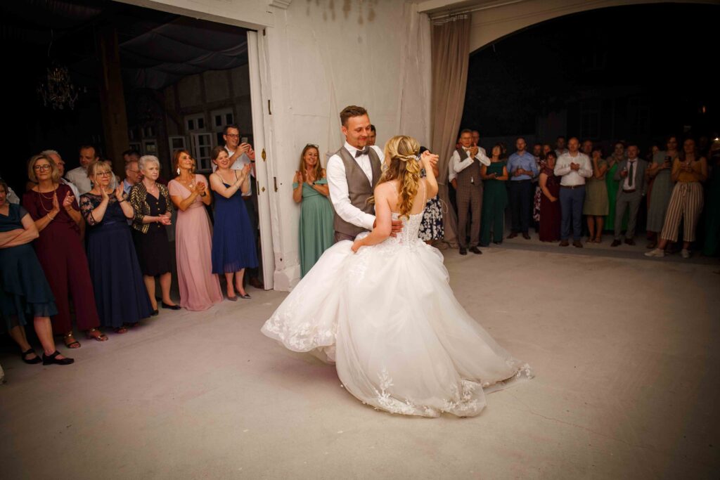Brautpaar tanzt, während die Gäste klatschen