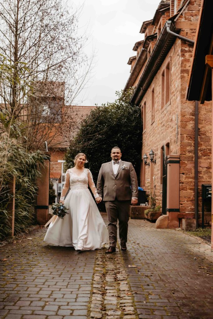 Brautpaar läuft Hand in Hand zum Fotoshooting