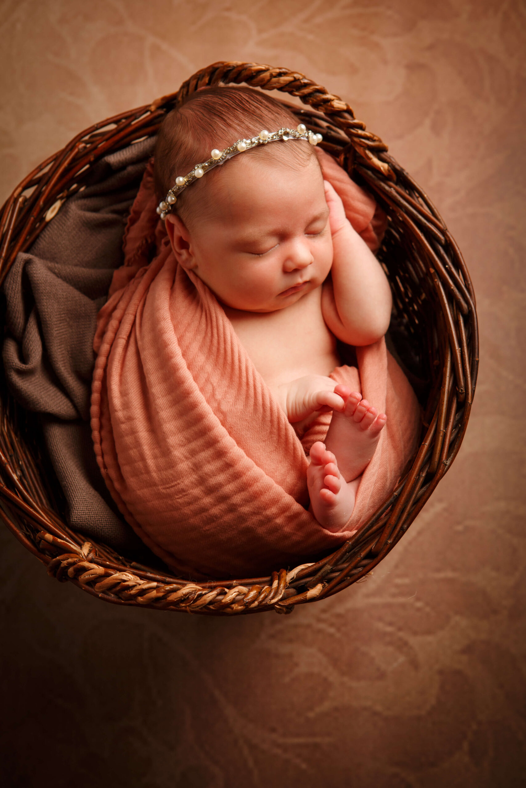 Neugeborenes liegt friedlich in einem geflochtenen Korb