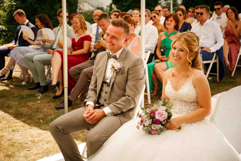 Braut und Bräutigam lachen gemeinsam bei der Zeremonie