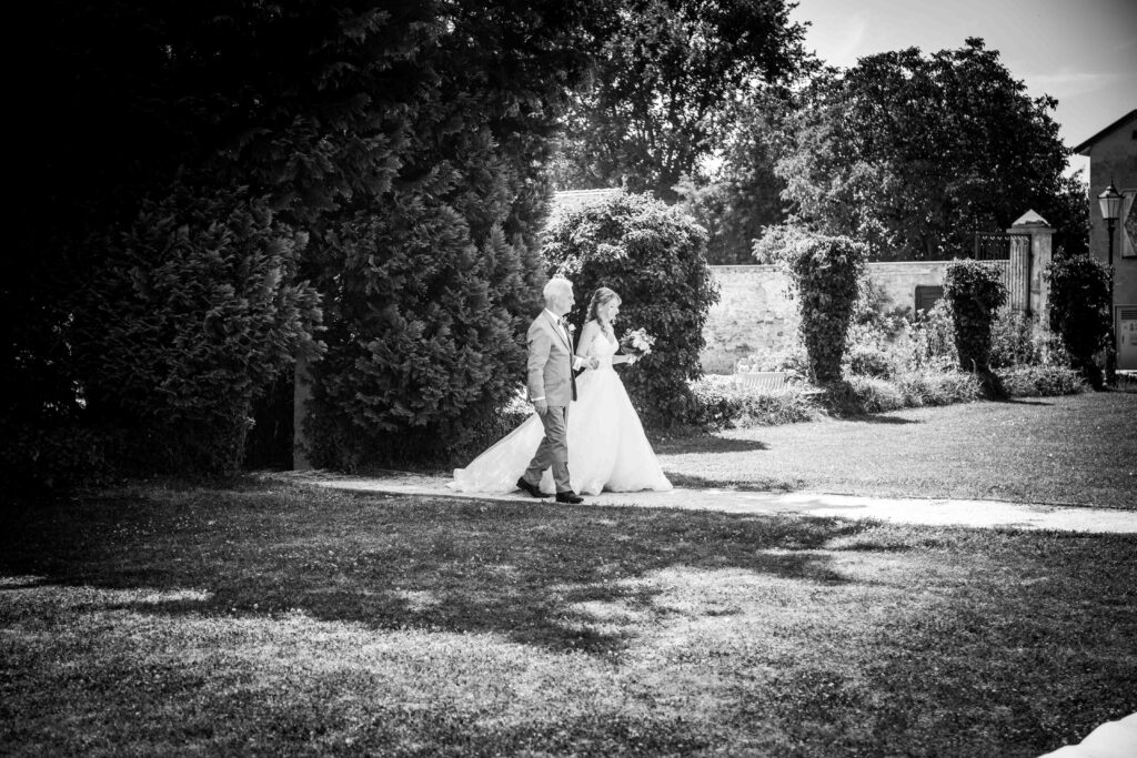 Braut geht Hand in Hand mit ihrem Vater