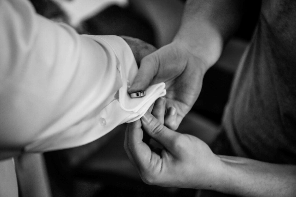 Hände knöpfen Manschetten am Ärmel