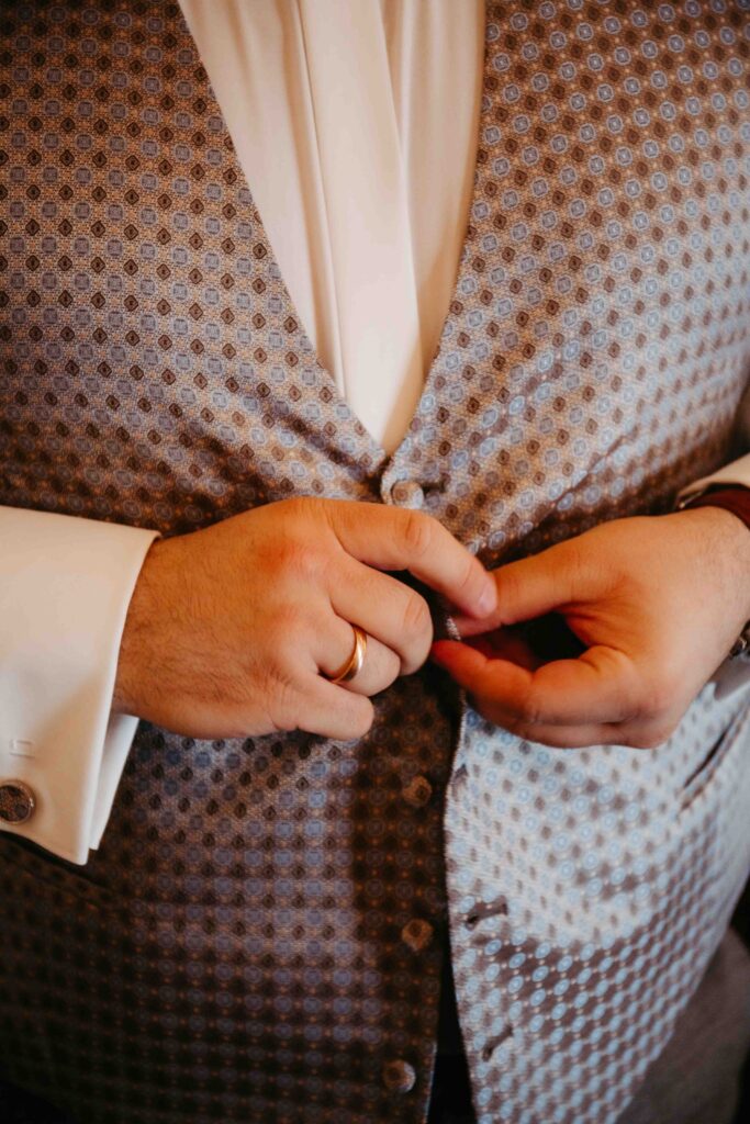 Bräutigam legt elegante Weste zum Anzug an