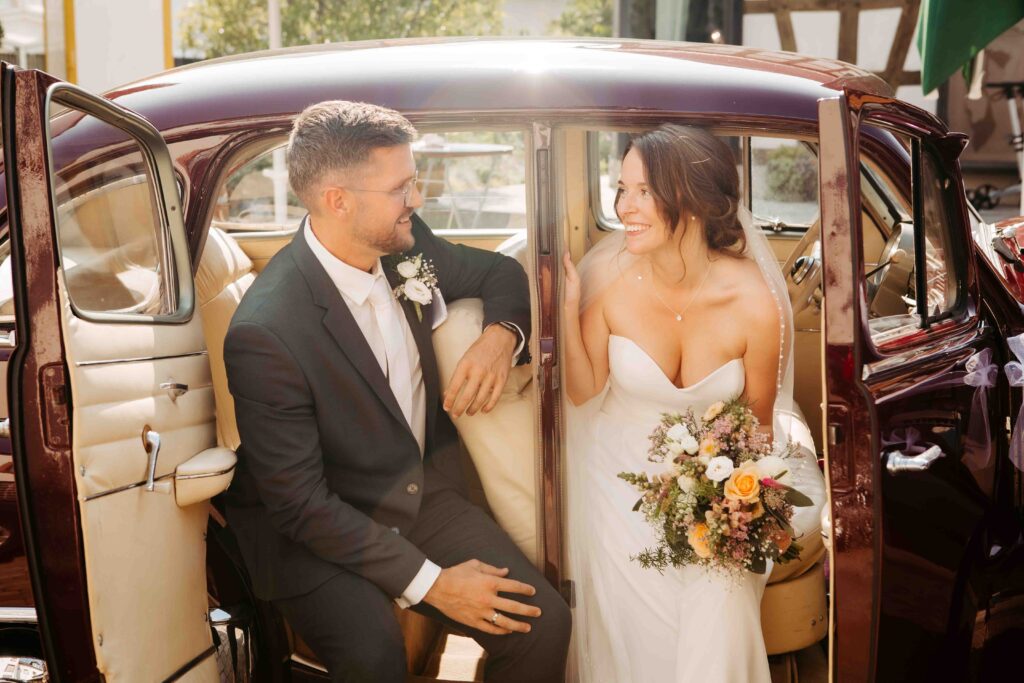 Inniger Moment: Braut und Bräutigam im Auto, verliebt in die Augen blickend