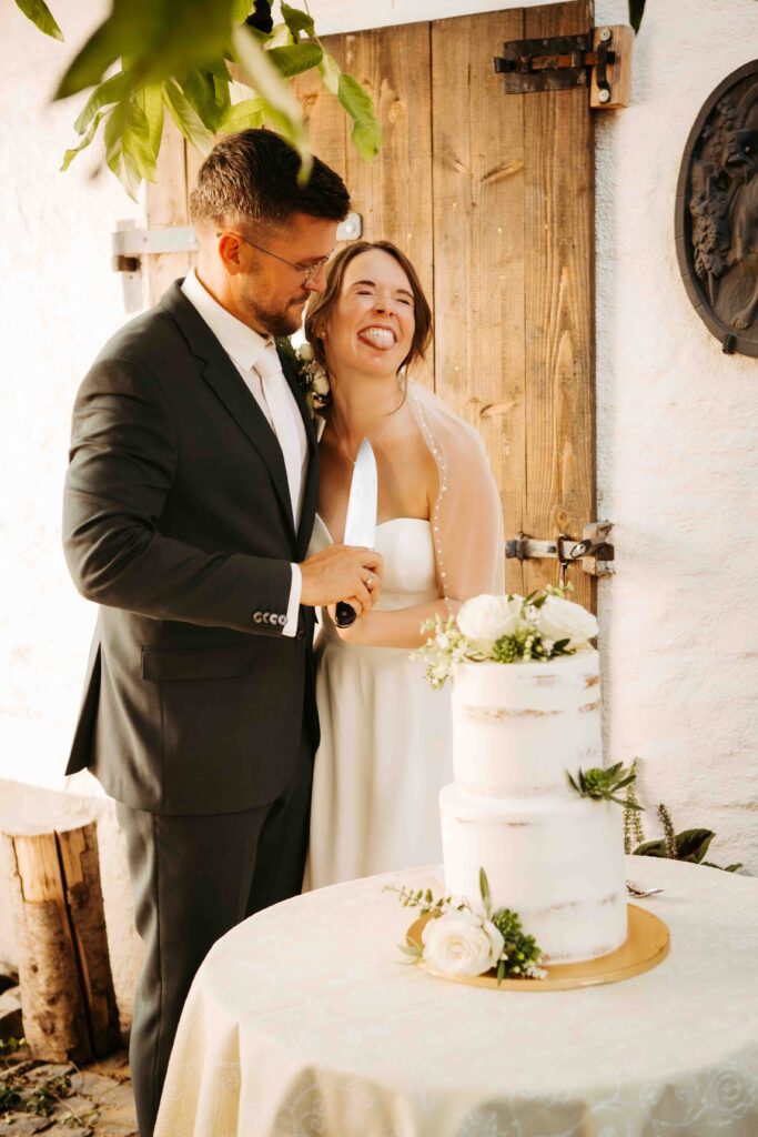 Lustiges Hochzeitsfoto: Torte im Vordergrund, Brautpaar im Hintergrund