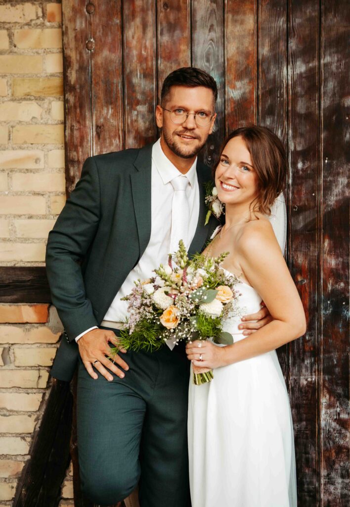 Braut und Bräutigam blicken lächelnd in die Kamera