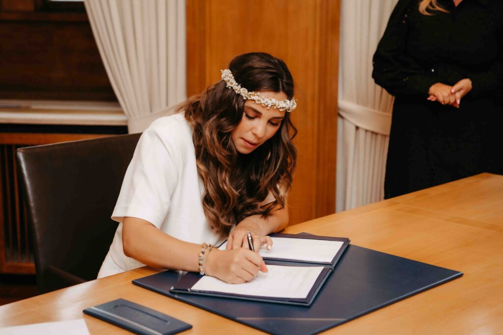 Detailaufnahme: Braut unterschreibt die Hochzeitsunterlagen