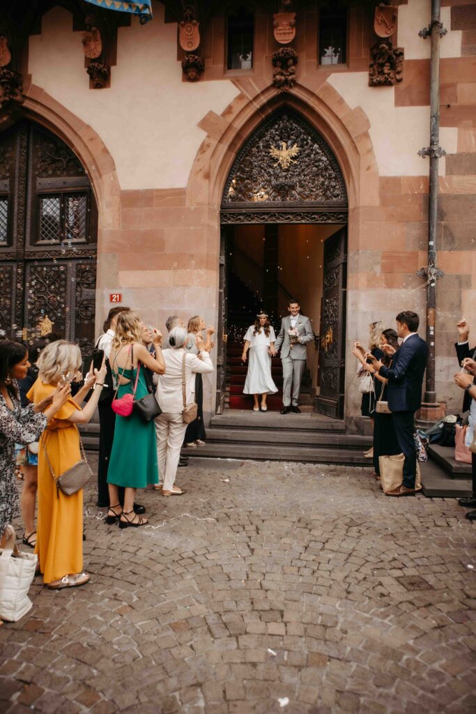 Glückliches Brautpaar verlässt den Römer nach der Eheschließung