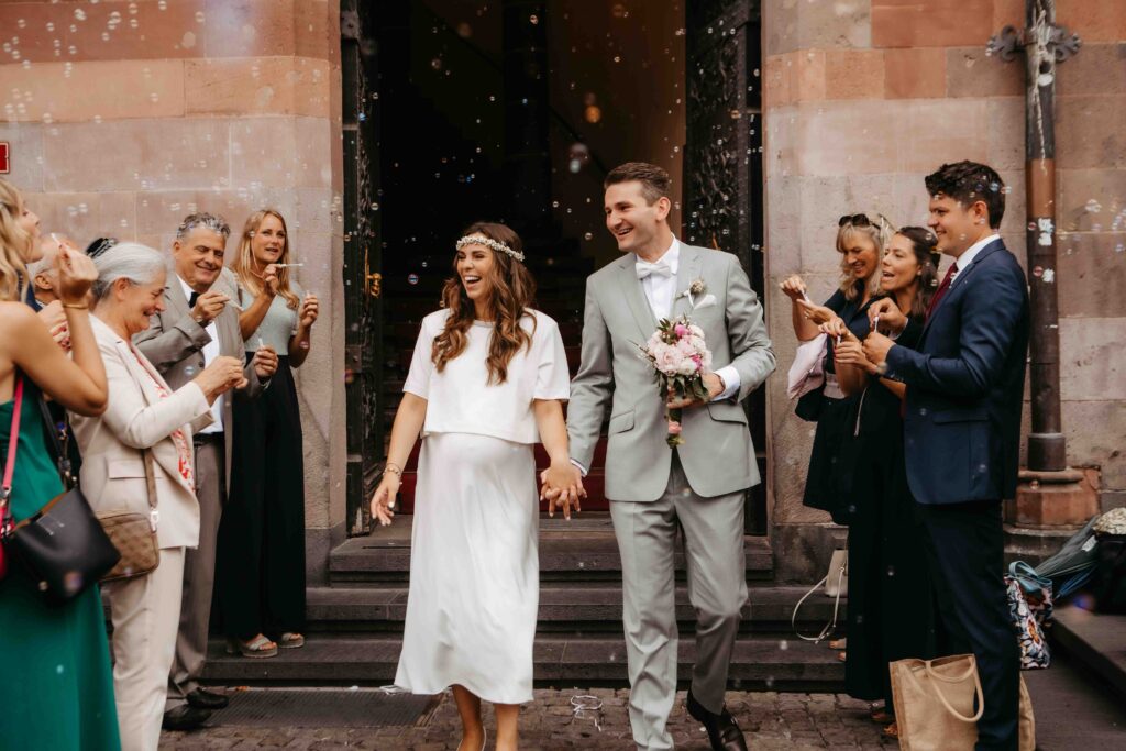 Frisch verheiratetes Paar läuft gemeinsam aus dem Gebäude