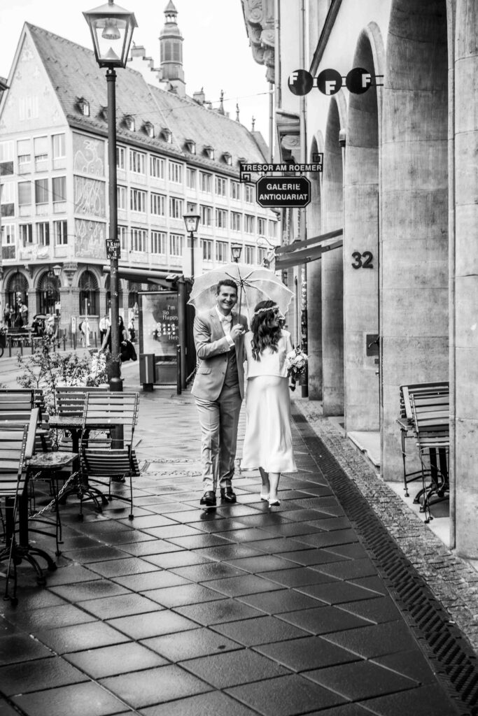 Romantischer Spaziergang des Brautpaars mit Schirm in Frankfurt