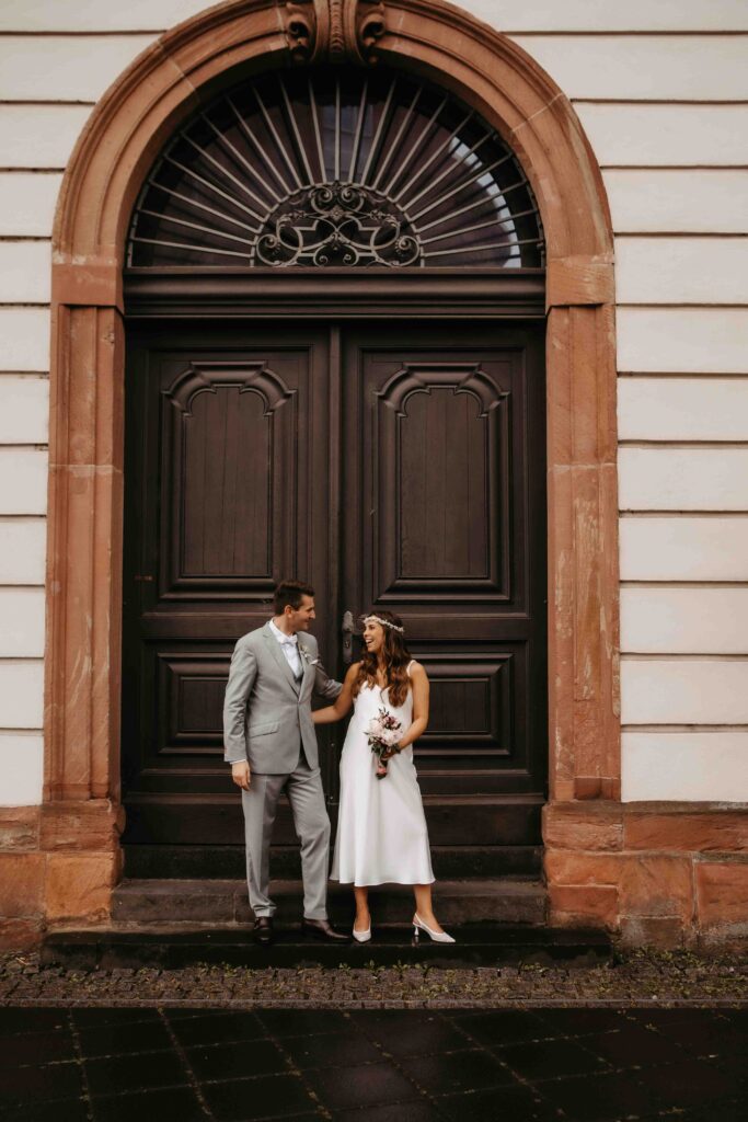 Paar posiert vor einer beeindruckenden Eingangstür