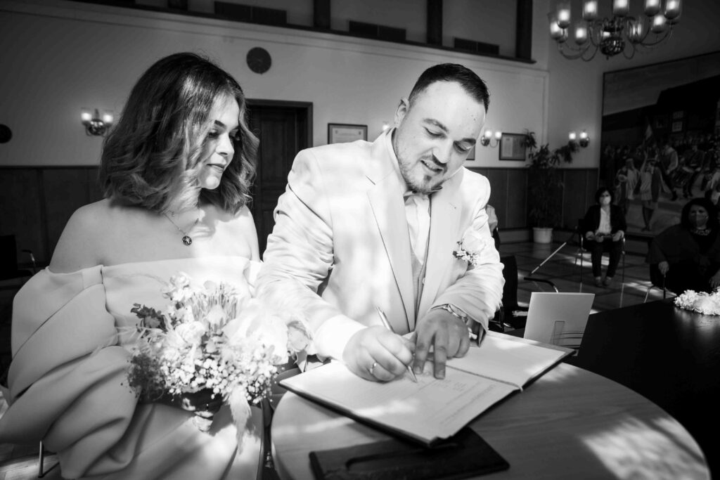 Hochzeitsmoment: Bräutigam setzt seine Unterschrift auf die Urkunde
