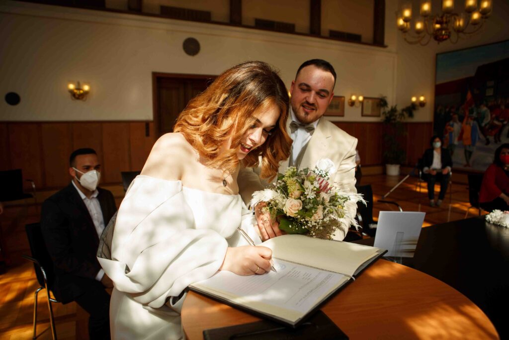 Standesamtliche Trauung – Braut setzt ihre Unterschrift