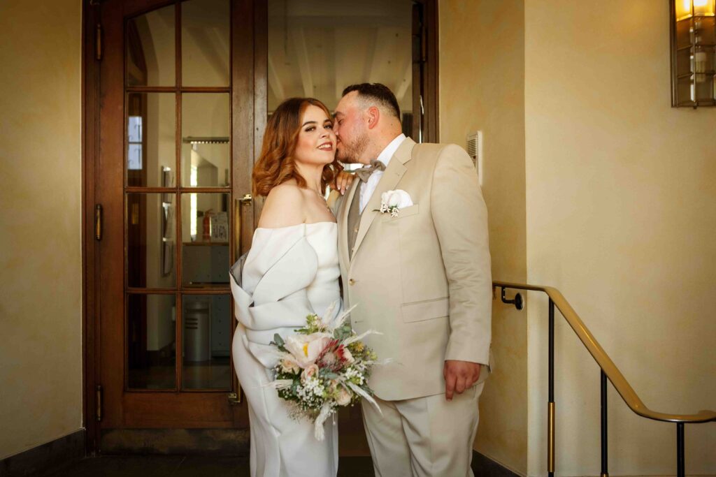 Zärtlicher Moment: Bräutigam küsst Braut beim Fotoshooting