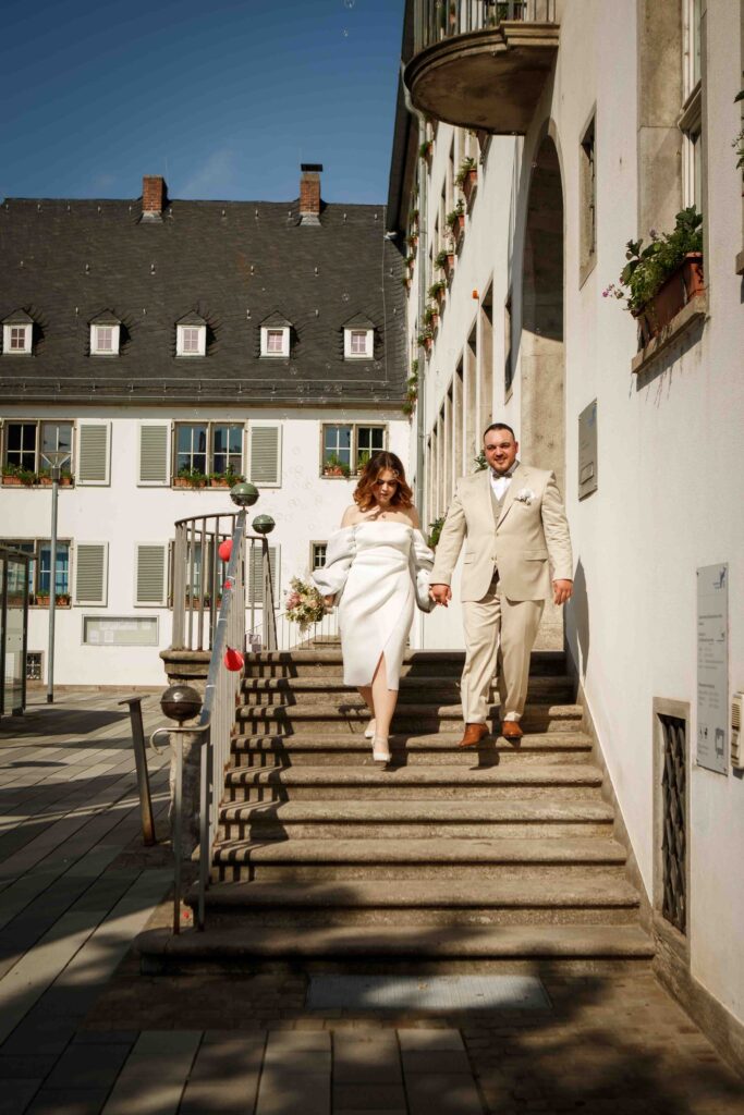 Brautpaar geht die Treppe des Standesamts Rüsselsheim hinunter