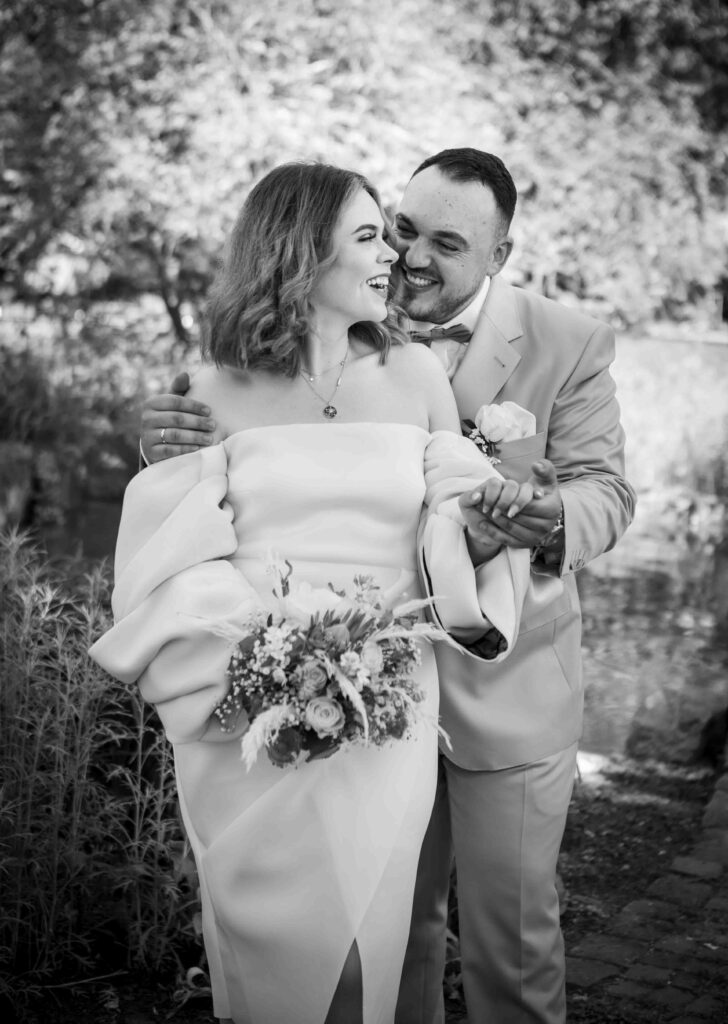 Glückliches Brautpaar, das beim Shooting gemeinsam lacht