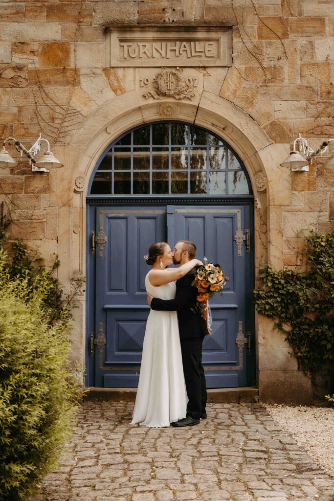 Brautpaar küßt sich vor der Turnhalle