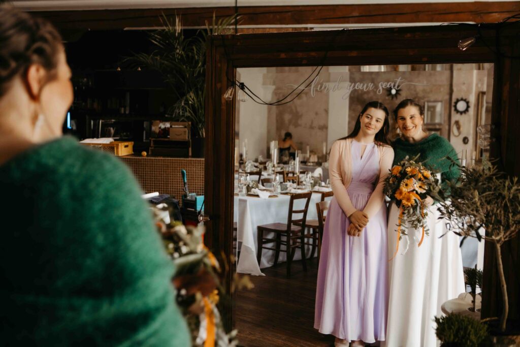 Braut macht ein Bild mit ihrer Tochter vor einem Spiegel.