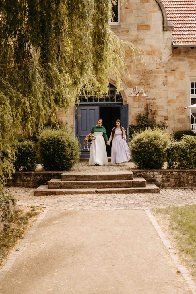Braut und Tochter kommen raus, richtung Trauung.