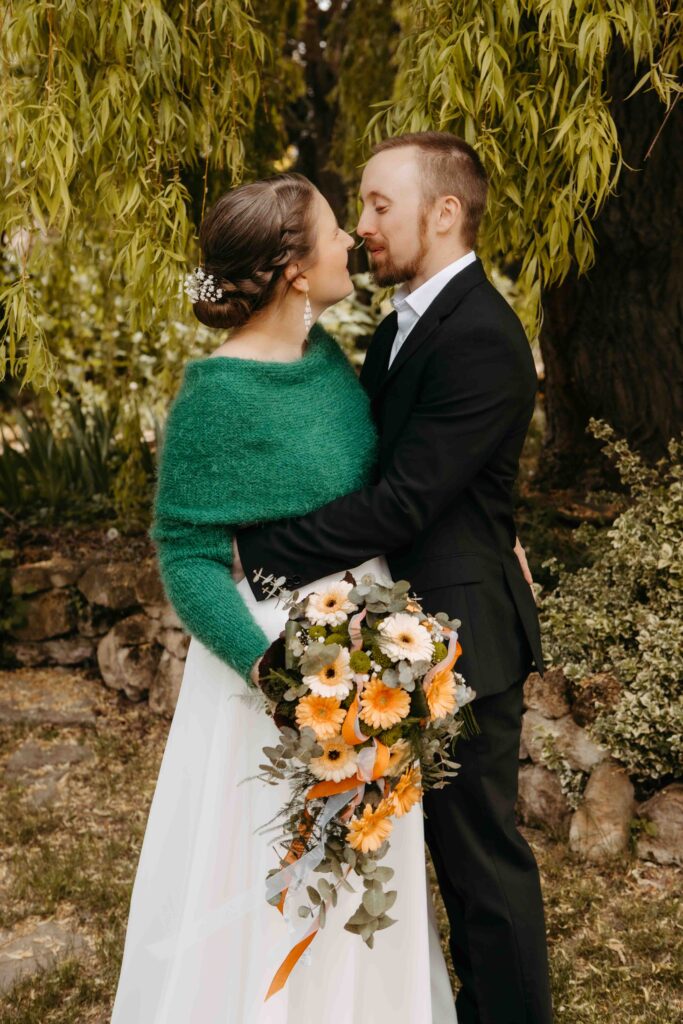 Brautpaar küßt sich vor der Location.