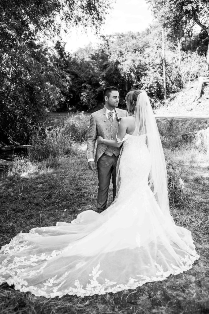 Man sieht das ganze Kleid und das Brautpaar