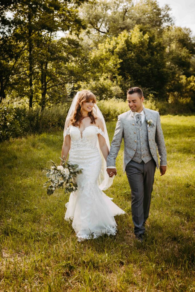 Brautpaar geht zusammen spazieren und halten die hand.