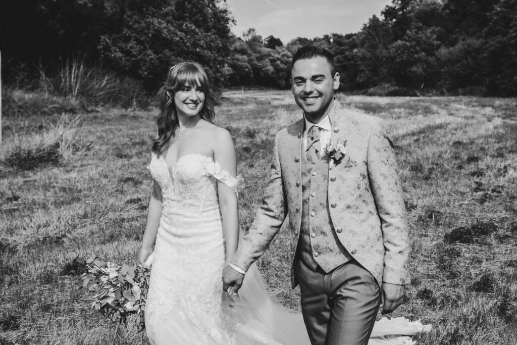 Brautpaar geht hand in hand spazieren.