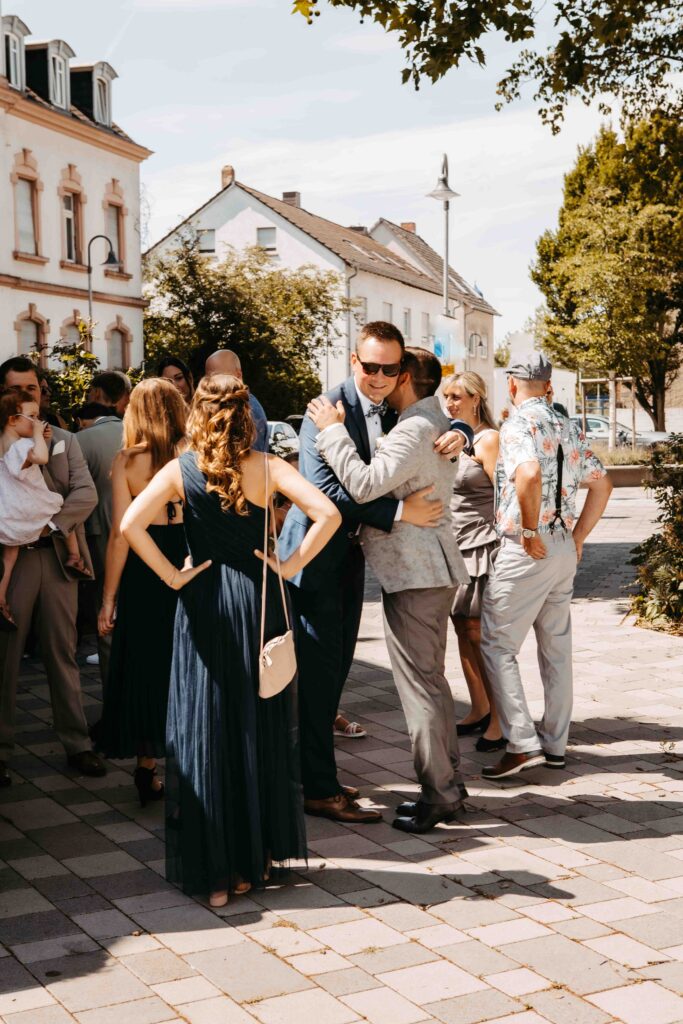 Gäste begrüßen den Bräutigam.